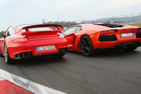 Rote Porsche-, Lamborghini-Autos beim Start Rückansicht