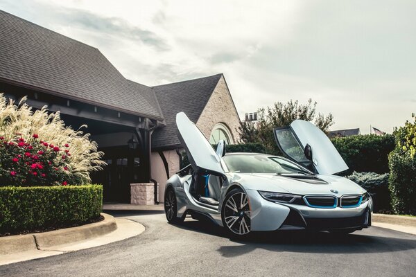 Luxury silver BMW i8 view on the background of the mansion