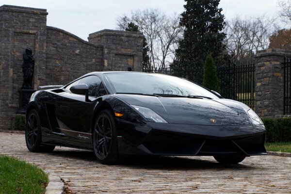 Lambirghini negro contra un fondo de pared de piedra