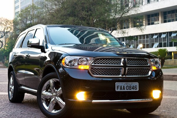 Coche con faros amarillos y ciudadela hacia atrás