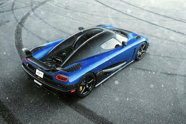 Supercar blu koenigsegg agera sulla strada invernale