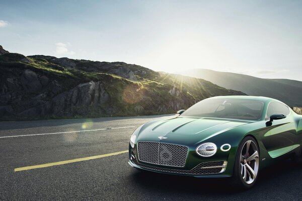 Cool green Ferrari rides on the road among the mountains