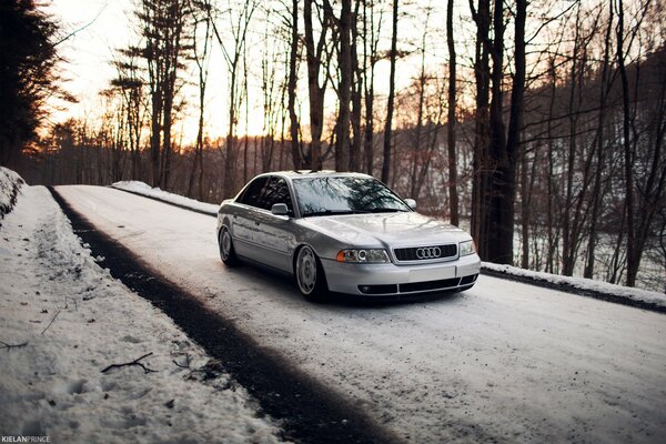 Серебристый Audi A4 снежный лес дорога