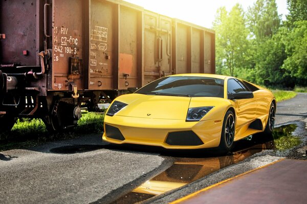 Yellow Lamborghini on the background of a freight car