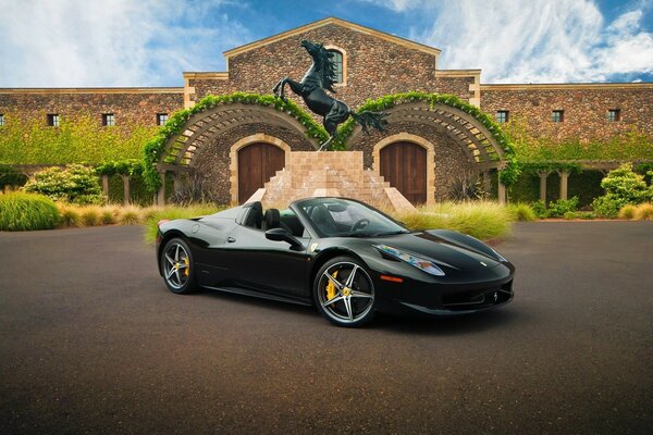 Schwarzes Cabrio vor dem Hintergrund der Villa mit einer Statue eines schwarzen Pferdes