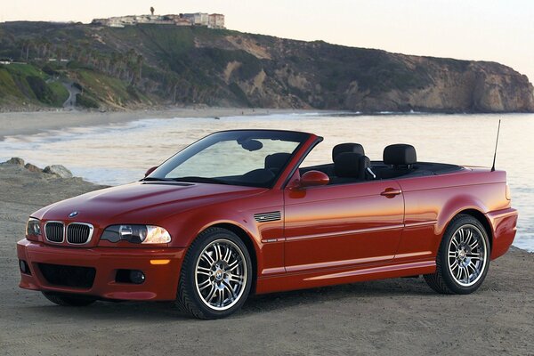 BMW E46 convertibile rosso in riva al mare di profilo