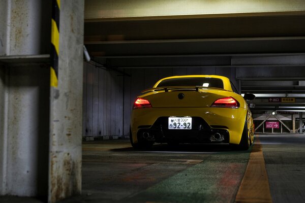 Bright yellow BMW z4 in a parking lot in Tokyo