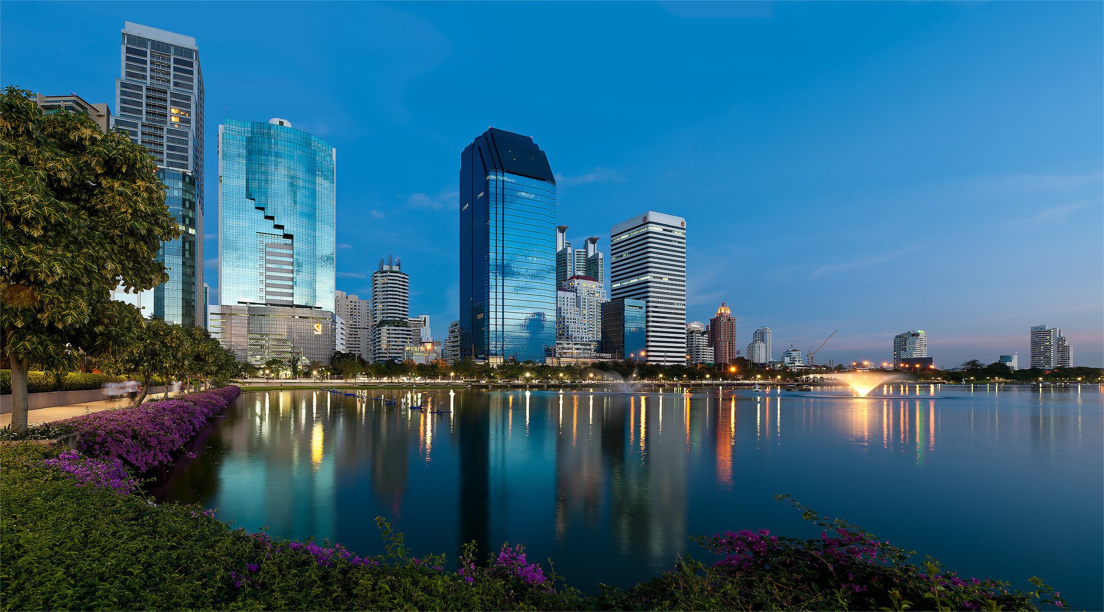 blumen bangkok thailand dämmerung wasser wolkenkratzer brunnen stadt reflexion häuser grün blumenbeete bäume abend lichter städte nachthimmel lichter der städte