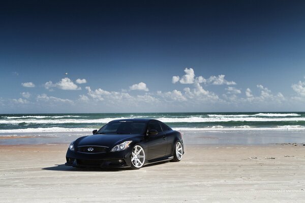 Black infiniti stands on the beach