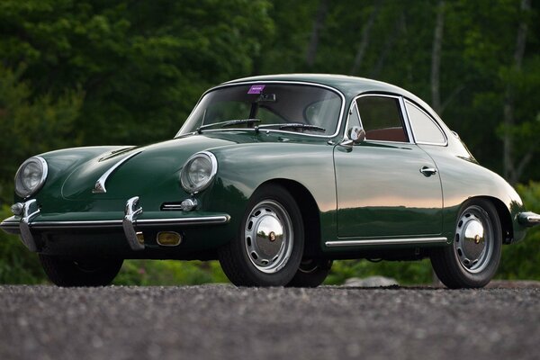 Coche retro Porsche verde en el bosque