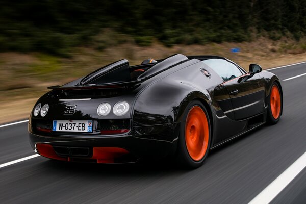 Black Bugatti Veyron ściga się z dużą prędkością na drodze