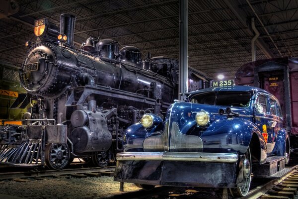 A museum with a train and a blue car
