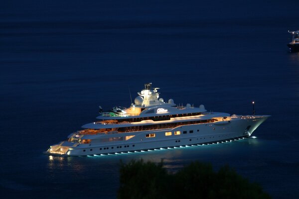 Ночная яхта среди синего моря с фонарями