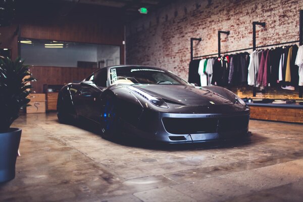 Un Ferrari F50 negro se encuentra en medio de un enorme granero de ladrillos
