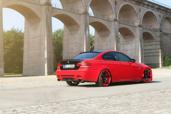 Red BMW with tuning among the arches