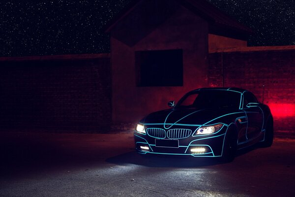 Bmw Z4 nera con luci blu e fari accesi di notte