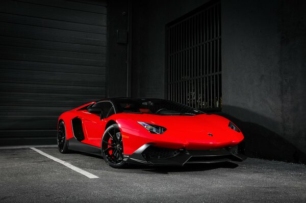 Lamborghini rouge se tient seul dans le garage noir