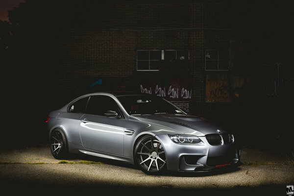 Grey BMW. Photo of a car at night against the background of a building