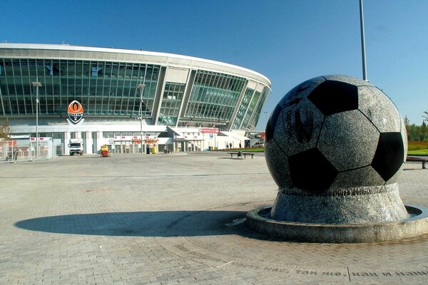 Pomnik piłki na tle stadionu