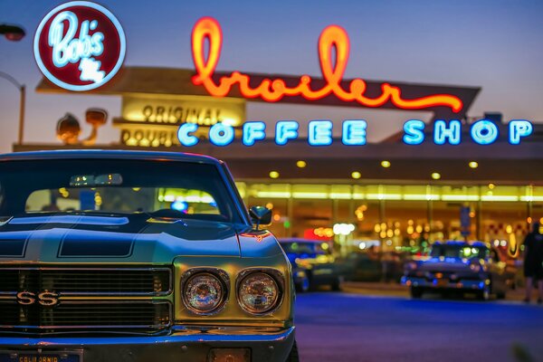 Macchina retrò su uno sfondo di caffè. Notte e luci