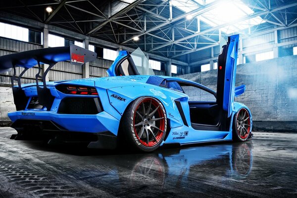 Niebieski supersamochód Lamborghini z tyłu z otwartymi drzwiami