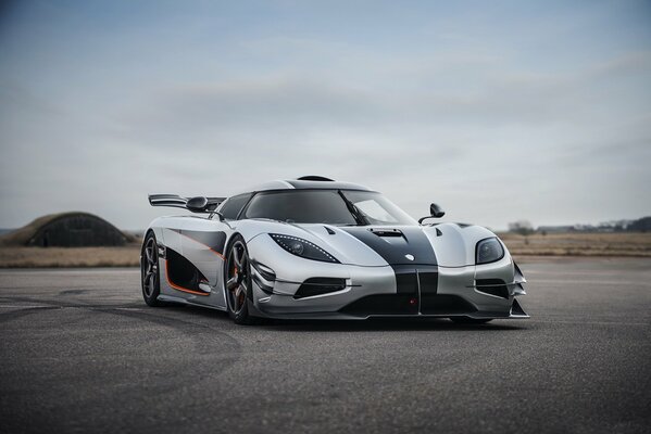 Voiture de sport gris sur la piste sur fond de hangar