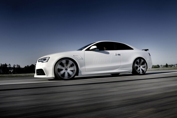 El Audi RS5 blanco viaja por la carretera