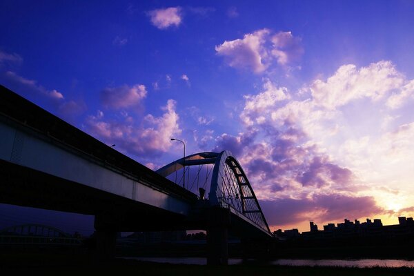 Brücke in der Stadt über den Fluss bei Sonnenuntergang