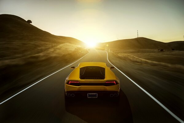 Vista trasera del coche amarillo lamborghini al atardecer