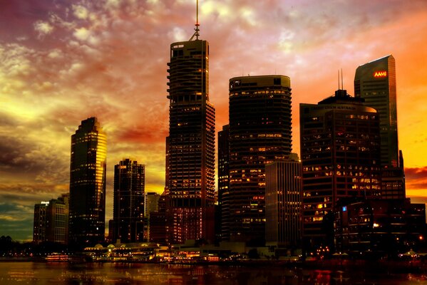 Evening lights of skyscrapers against a pink sky at sunset