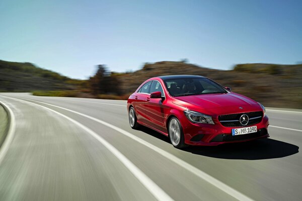 Red Mercedes Benz is flying on a country road