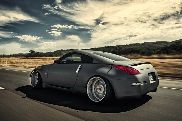 Серебристый nissan 350z мчит по трассе