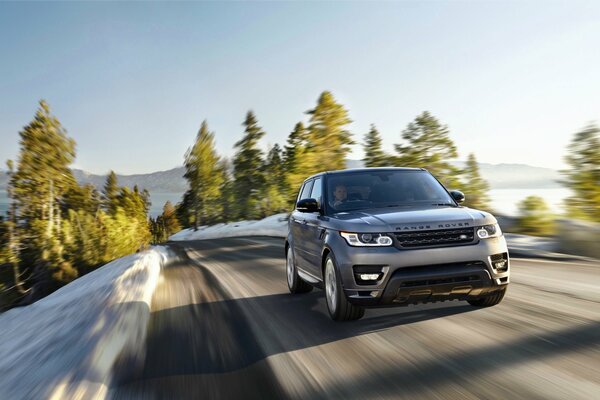 Range rover im Winter , Range Rover auf einer Winterstraße außerhalb der Stadt , range Rover in Bewegung auf einer Autobahn außerhalb der Stadt , range Rover in Bewegung vor dem Hintergrund von Bergen und Wäldern