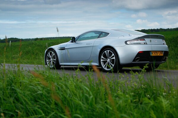 Aston Martin sur la route sur fond d herbe