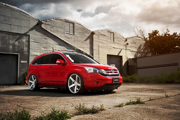 La voiture rouge se trouve dans les vieilles granges grises