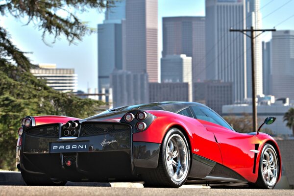 El deportivo pagani rojo en el fondo de la ciudad