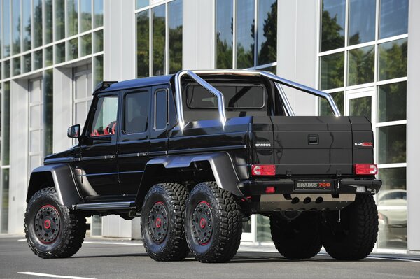 Black mercedes-benz Brabus G63 stopped in front of a car dealership