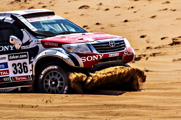 SUV Toyoty pokonuje piasek w Dakarze