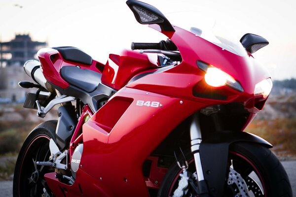 Moto Ducati rouge avec phares allumés