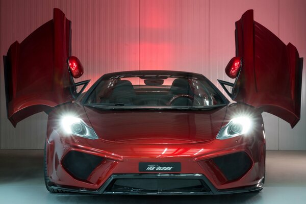 The red McLaren mp4-12c stands with the headlights on and the doors open