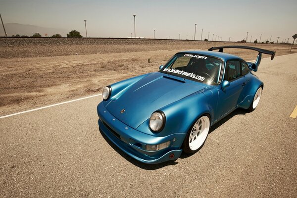 Porsche 911 blu su una pista deserta