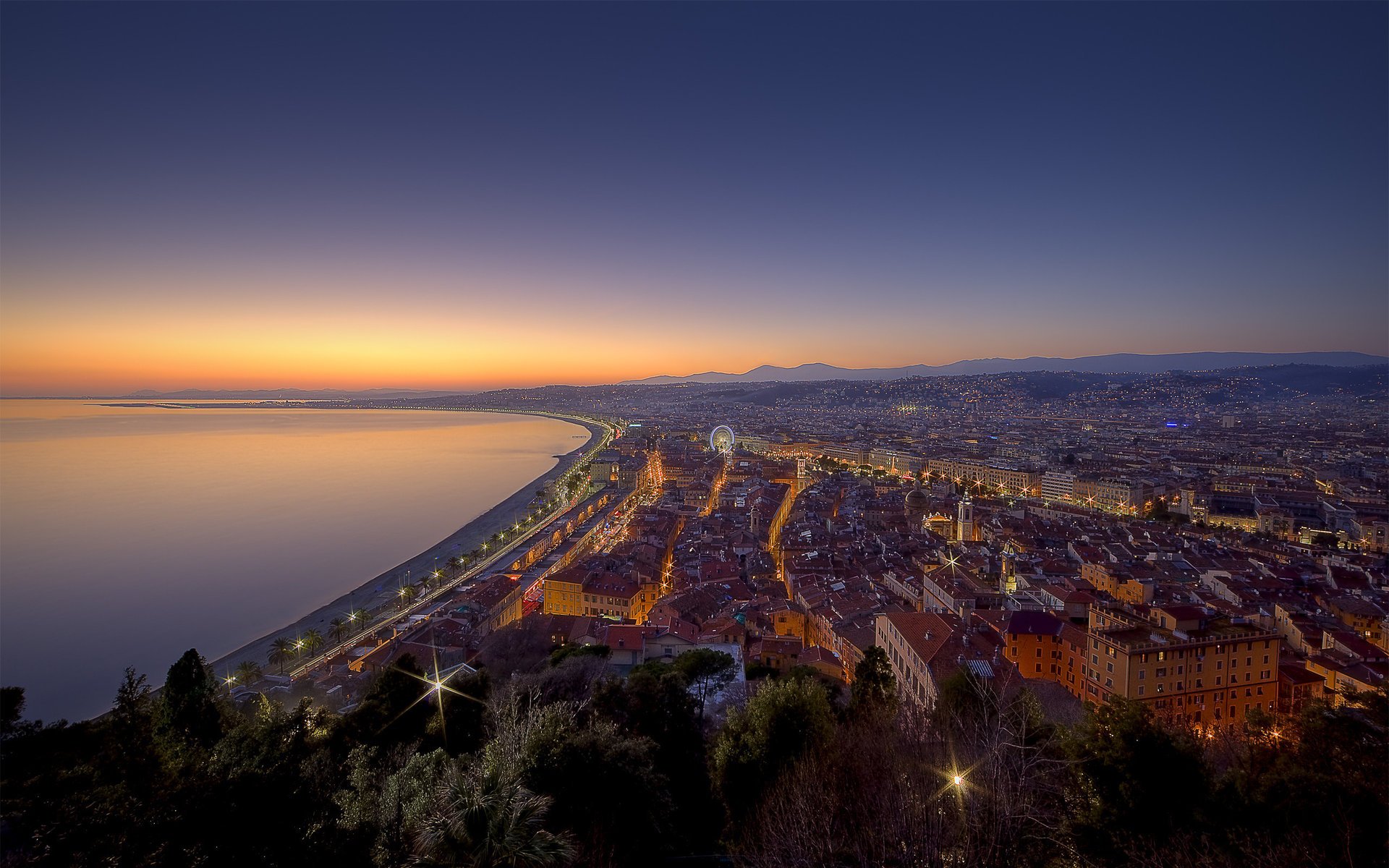 ночь good night nice панорама кроны деревьев франция город побережье вода гладь небо свет огни вид фонари набережная дома здания деревья горизонт закат