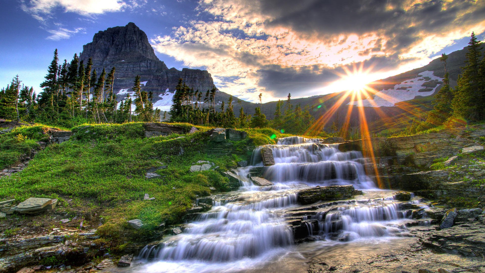 natura cascata rocce montagne paesaggio sole raggi erba verde corrente nuvole alberi ruscelli tramonto