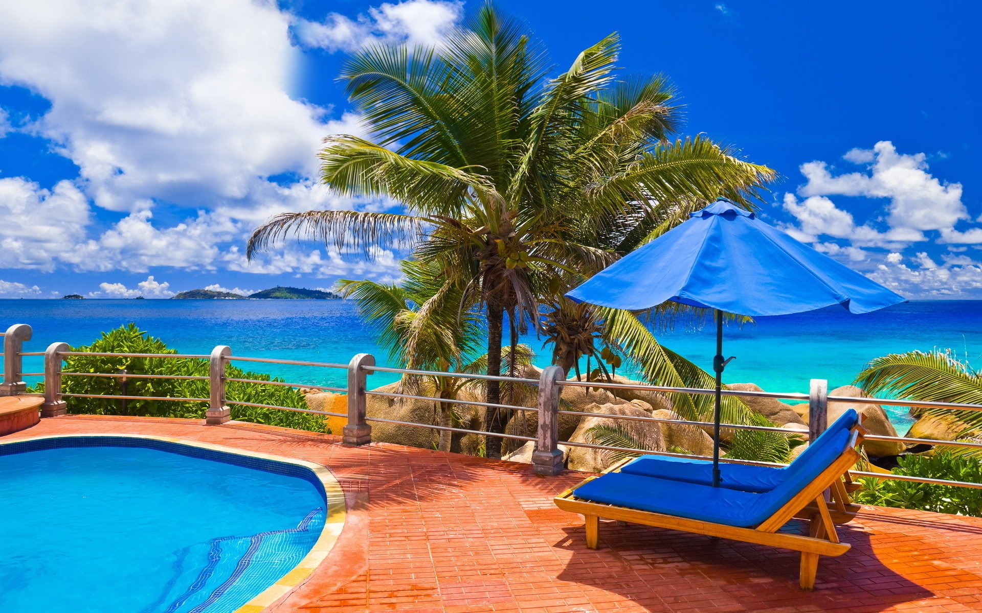 mare piscina palme nuvole cielo blu acqua blu sedie a sdraio relax ombrello pietre recinzione acqua cielo