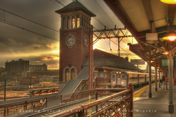 Train station with clock and arriving train