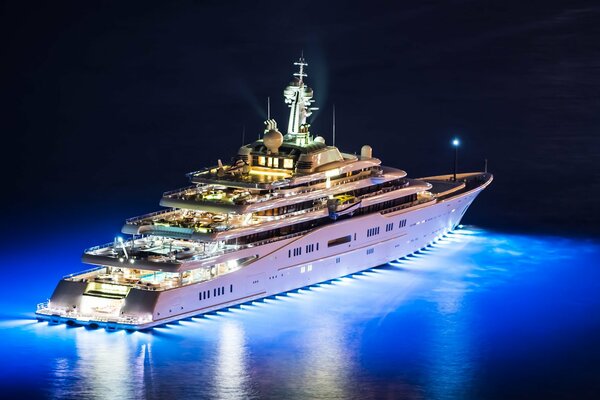 Un yacht cool avec des lumières navigue sur l eau la nuit