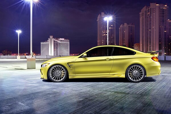 BMW M4 jaune sur le fond de la ville de nuit