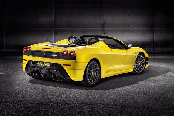 A beautiful yellow Ferrari in a black bunker