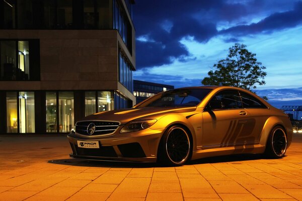 Hermoso mercedes de plata de pie en la noche cerca de la casa