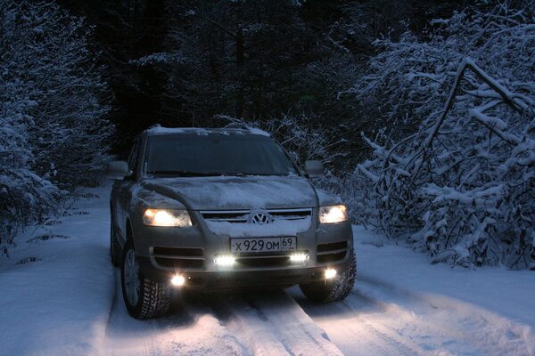 SUV mitten im Winterwald auf schmaler Straße